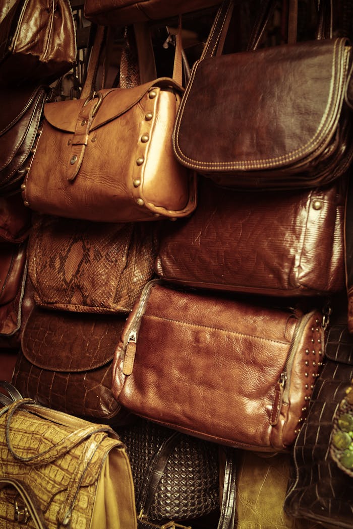 who-we-are A collection of vintage leather bags in various styles and colors showcased in a market stall.