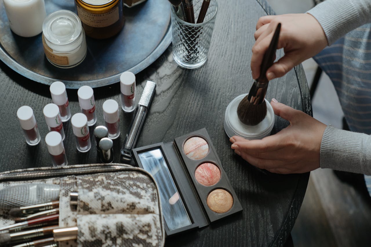 The Art of Drawing Readers In: Your attractive post title goes here A flatlay of makeup and beauty products including eyeshadows, lipsticks, and brushes on a table.